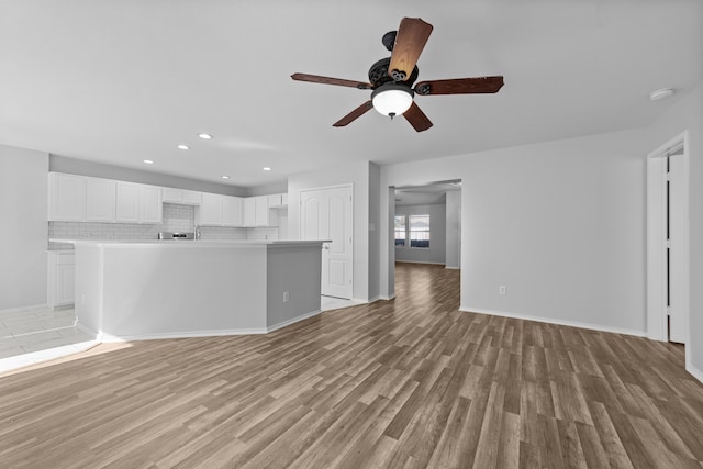 unfurnished living room with ceiling fan and light wood-type flooring