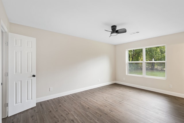 unfurnished room with ceiling fan and dark wood-type flooring