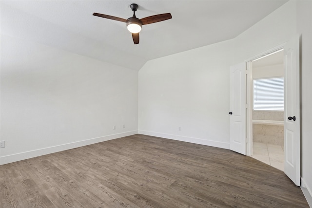 unfurnished room featuring dark hardwood / wood-style flooring, vaulted ceiling, and ceiling fan