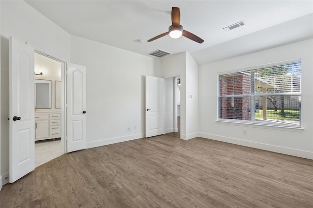 unfurnished bedroom with ensuite bath, ceiling fan, and light hardwood / wood-style flooring