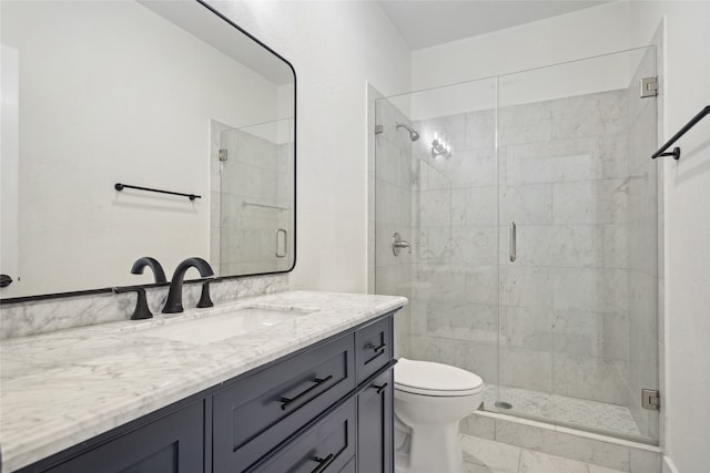 bathroom featuring vanity, toilet, and an enclosed shower