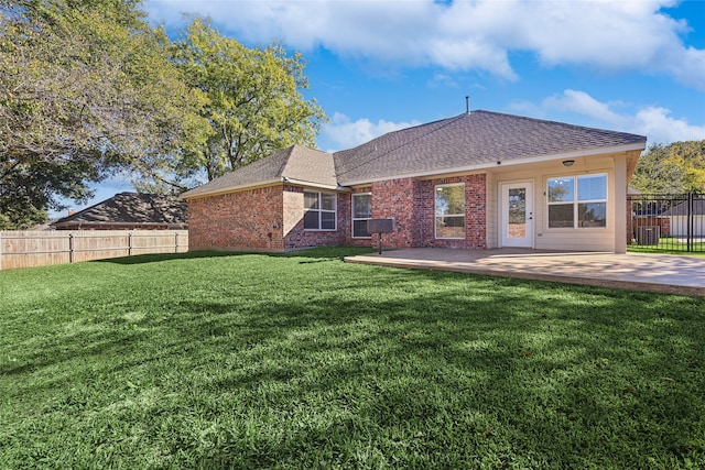 back of property with a patio area and a yard