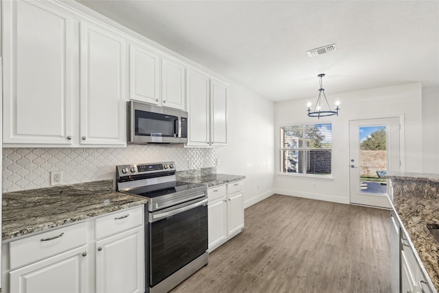 kitchen with white cabinets, light hardwood / wood-style floors, and stainless steel appliances