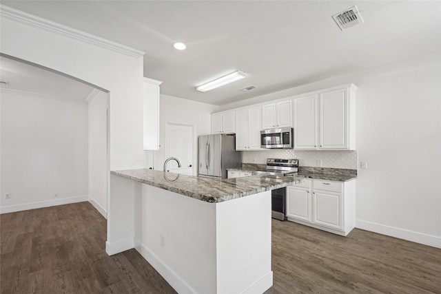 kitchen with crown molding, white cabinetry, dark hardwood / wood-style flooring, kitchen peninsula, and stainless steel appliances