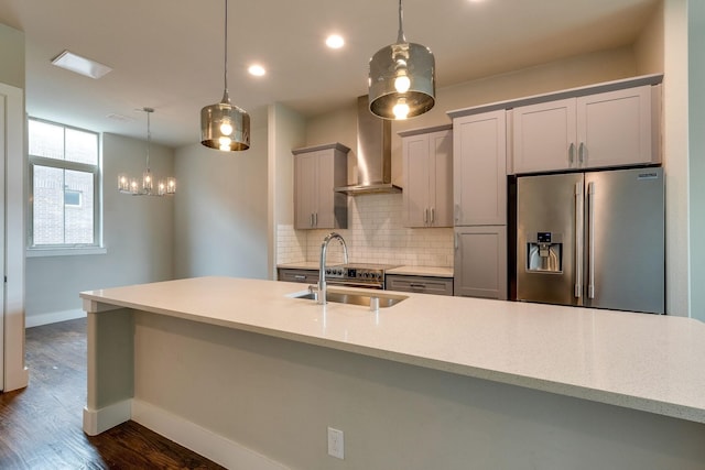 kitchen with gray cabinetry, wall chimney range hood, stainless steel fridge with ice dispenser, dark hardwood / wood-style floors, and decorative light fixtures