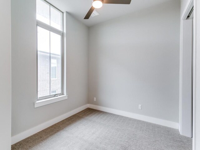 empty room with ceiling fan and carpet