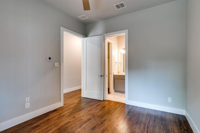 unfurnished bedroom featuring hardwood / wood-style floors, ceiling fan, and connected bathroom