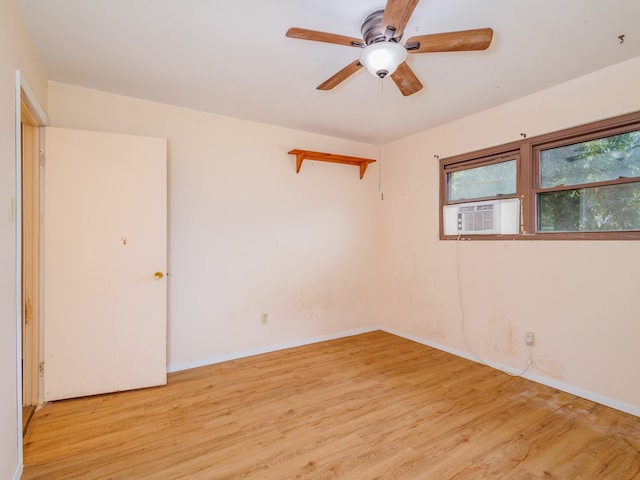 spare room featuring ceiling fan, light hardwood / wood-style flooring, and cooling unit