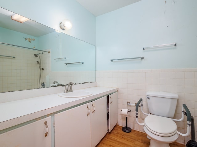 bathroom with vanity, toilet, wood-type flooring, and tile walls