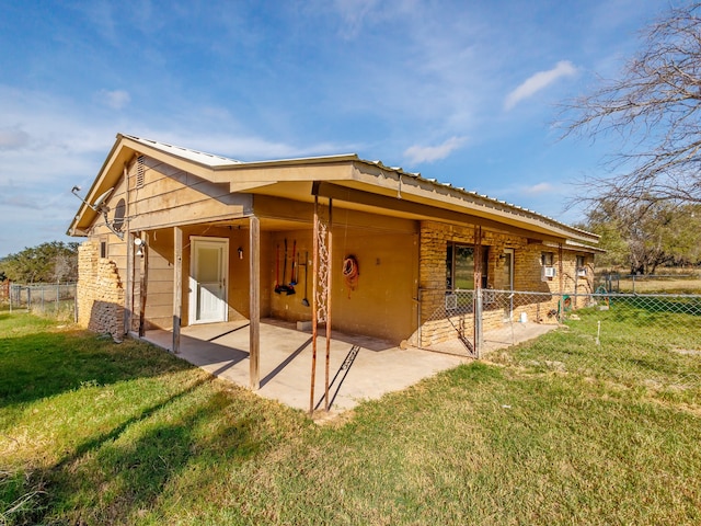 rear view of house featuring a lawn and a patio area