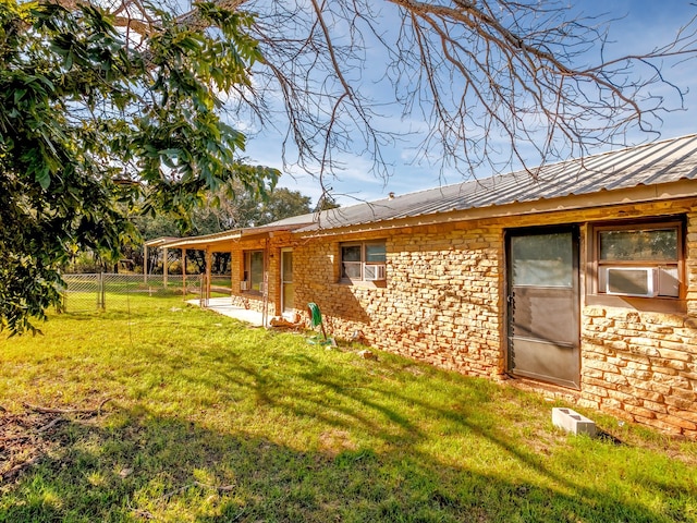 rear view of house featuring cooling unit and a lawn