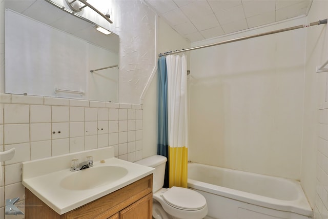 full bathroom with shower / bath combination with curtain, vanity, toilet, and tile walls