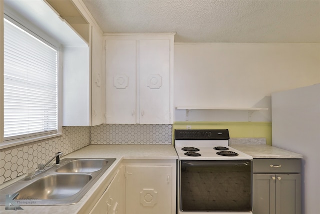 kitchen with tasteful backsplash, a textured ceiling, white range with electric stovetop, sink, and gray cabinets