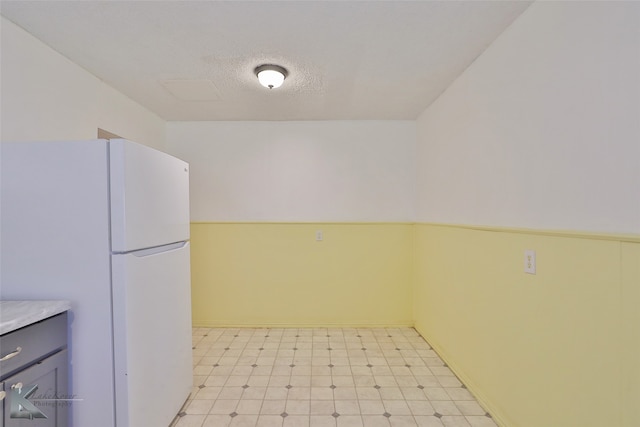 kitchen with white fridge and a textured ceiling