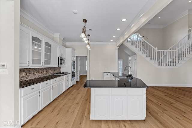 kitchen featuring white cabinetry, sink, stainless steel appliances, and light wood-type flooring