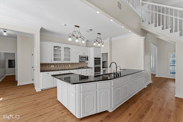 kitchen featuring sink, white cabinets, stainless steel appliances, and light hardwood / wood-style flooring