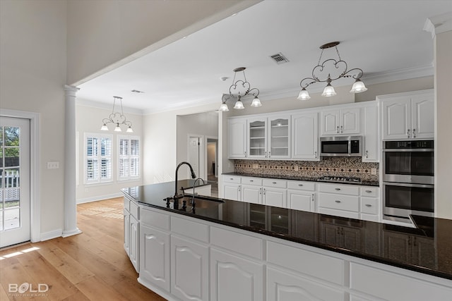 kitchen featuring decorative light fixtures, stainless steel appliances, white cabinetry, and sink