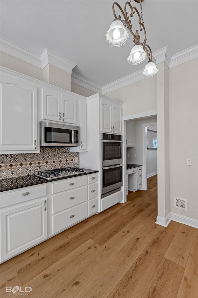 kitchen featuring pendant lighting, backsplash, light hardwood / wood-style flooring, white cabinetry, and stainless steel appliances