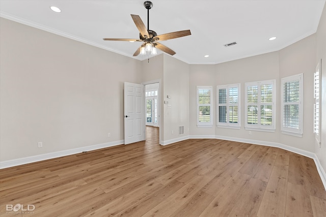 unfurnished room featuring a high ceiling, light wood-type flooring, ceiling fan, and crown molding