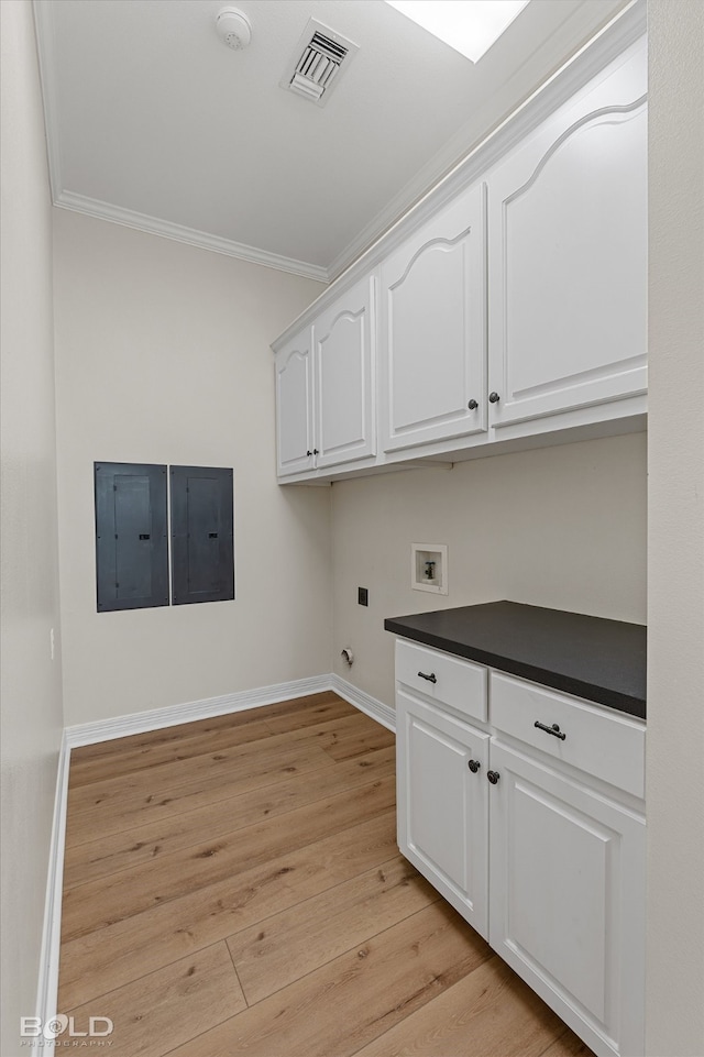 clothes washing area with hookup for a washing machine, light wood-type flooring, crown molding, and electric panel