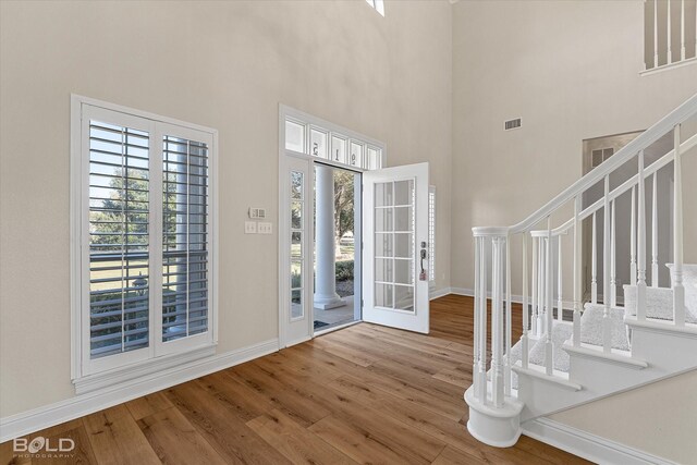 foyer with a towering ceiling and hardwood / wood-style flooring