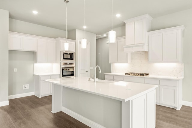 kitchen featuring a kitchen island with sink, stainless steel appliances, dark wood-style floors, and white cabinets