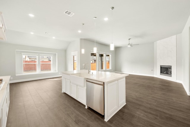 kitchen featuring visible vents, a sink, stainless steel dishwasher, open floor plan, and a high end fireplace