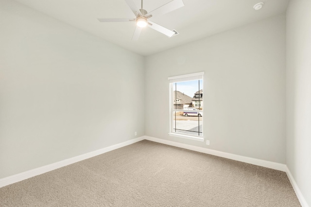 carpeted empty room featuring a ceiling fan and baseboards