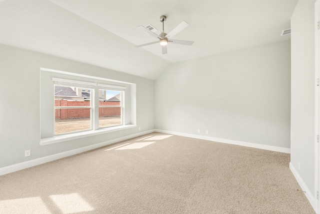 unfurnished room featuring visible vents, a ceiling fan, carpet flooring, baseboards, and vaulted ceiling