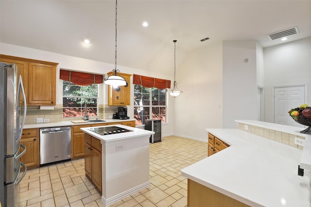 kitchen featuring a high ceiling, sink, hanging light fixtures, a kitchen island, and stainless steel appliances