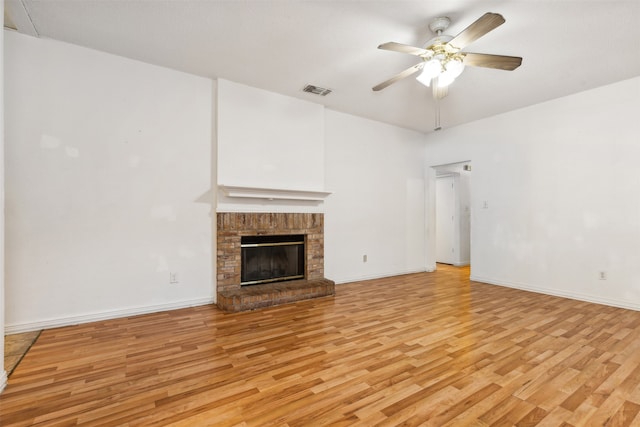 unfurnished living room with ceiling fan, light hardwood / wood-style floors, and a fireplace