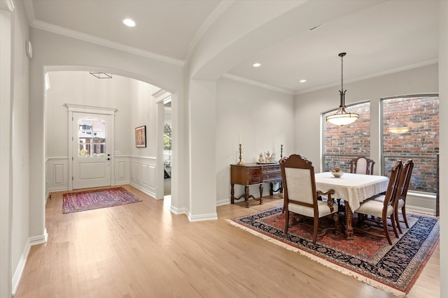 dining area with crown molding and light wood-type flooring