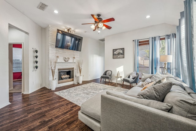 living room with a fireplace, dark hardwood / wood-style floors, and ceiling fan