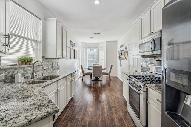 kitchen featuring decorative light fixtures, white cabinets, and stainless steel appliances