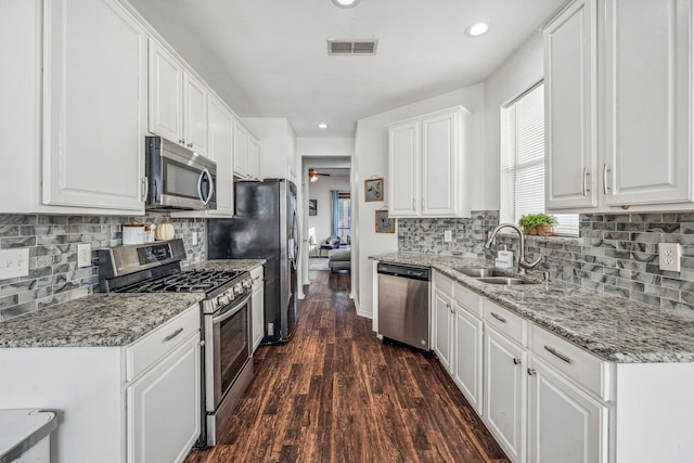 kitchen with dark hardwood / wood-style flooring, sink, white cabinets, light stone countertops, and stainless steel appliances