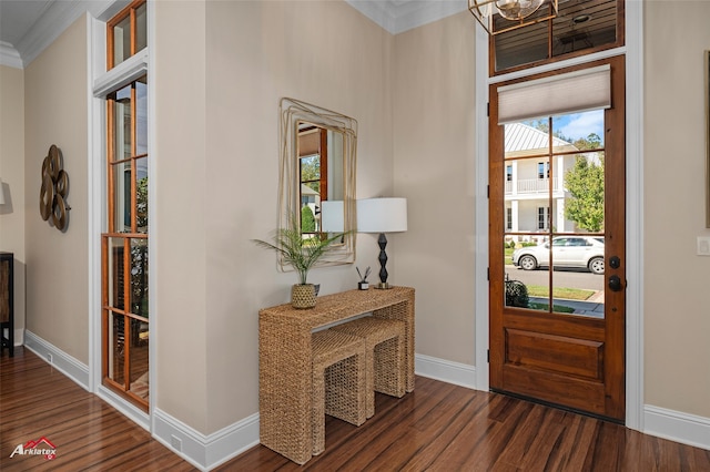 foyer entrance featuring dark hardwood / wood-style floors, crown molding, and an inviting chandelier