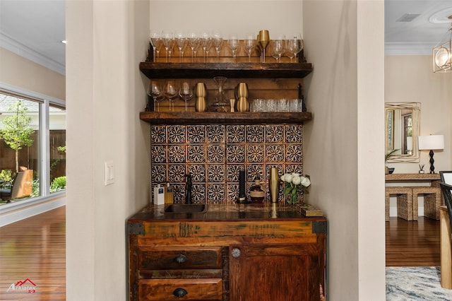 bar featuring crown molding and hardwood / wood-style floors