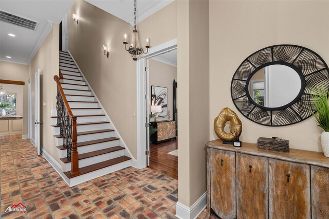 staircase featuring a wealth of natural light, crown molding, and a notable chandelier