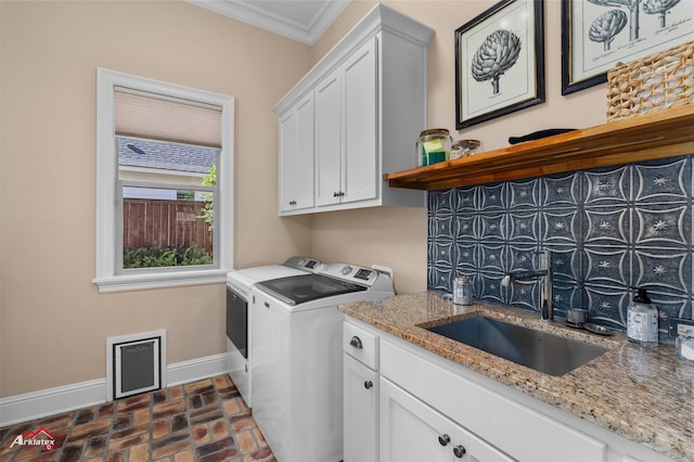 washroom featuring crown molding, sink, cabinets, and independent washer and dryer