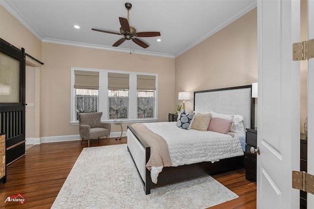 bedroom featuring dark hardwood / wood-style floors, ceiling fan, a barn door, and crown molding