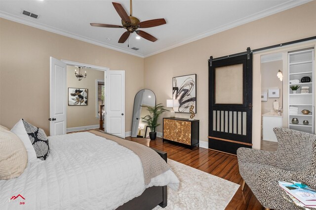 bedroom featuring ensuite bath, ceiling fan, dark wood-type flooring, a barn door, and crown molding