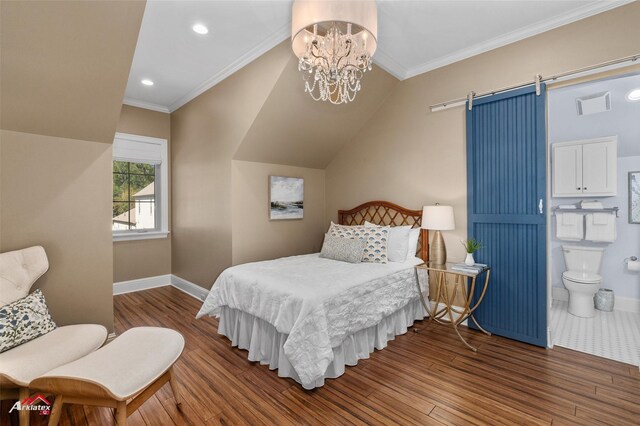 bedroom featuring dark wood-type flooring, crown molding, ensuite bath, a barn door, and a chandelier