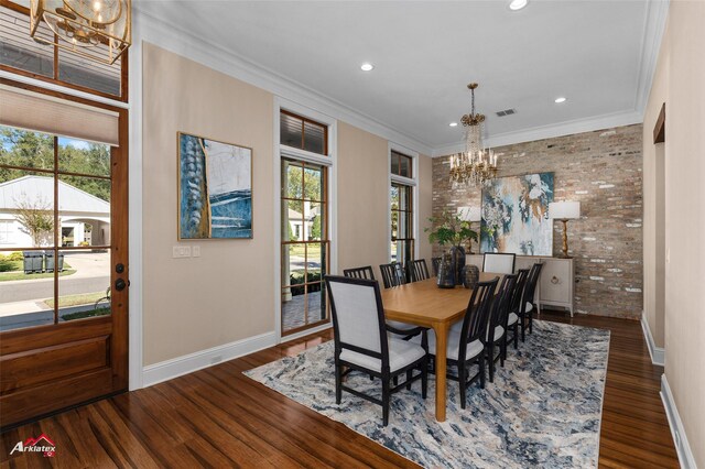 dining room featuring ornamental molding, dark hardwood / wood-style flooring, a healthy amount of sunlight, and a notable chandelier