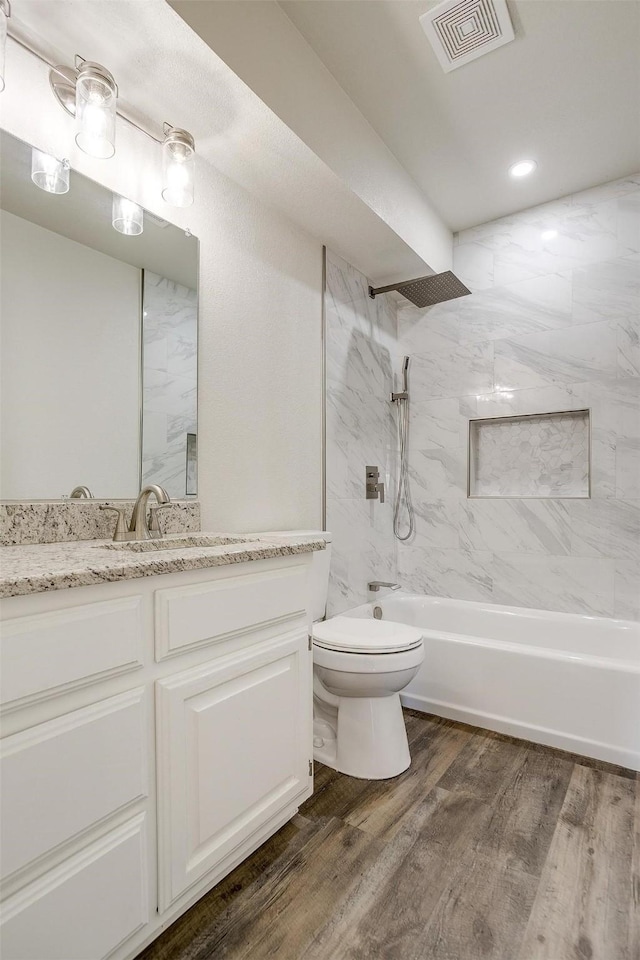 728 E 3rd St, Springtown, TX 76082 - bathroom with toilet, vanity, washtub / shower combination, and wood finished floors