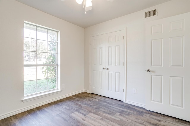 unfurnished bedroom with light wood-type flooring, a closet, and ceiling fan