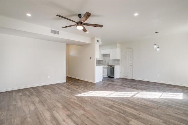 unfurnished living room with ceiling fan, light hardwood / wood-style floors, and sink