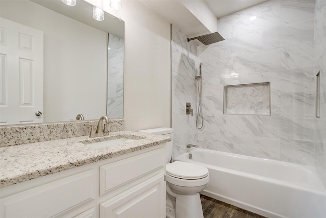 full bathroom featuring hardwood / wood-style floors, vanity, toilet, and tiled shower / bath