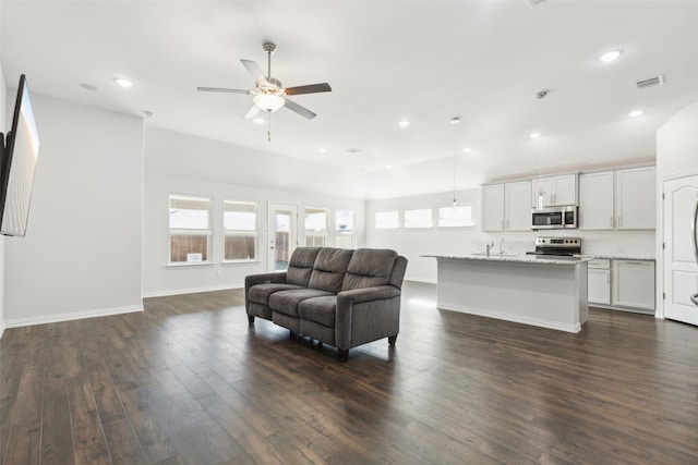 living room featuring ceiling fan and dark wood-type flooring