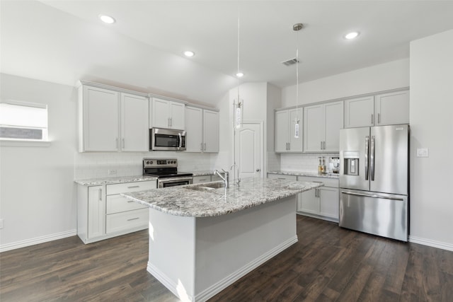 kitchen with dark hardwood / wood-style flooring, light stone countertops, stainless steel appliances, and hanging light fixtures