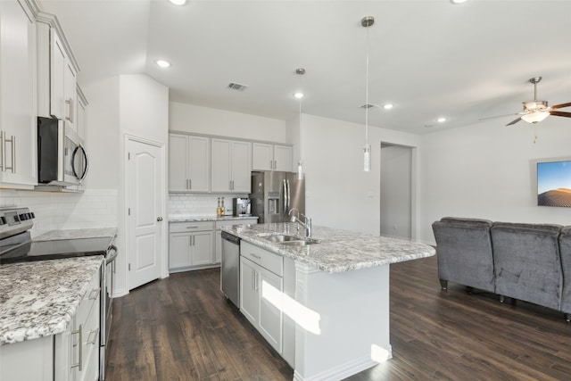 kitchen featuring stainless steel appliances, sink, decorative light fixtures, a center island with sink, and dark hardwood / wood-style floors